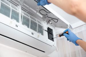 Man Repairing An Air Conditioner — Allchin Airconditioning & Refrigeration in Currimundi, QLD